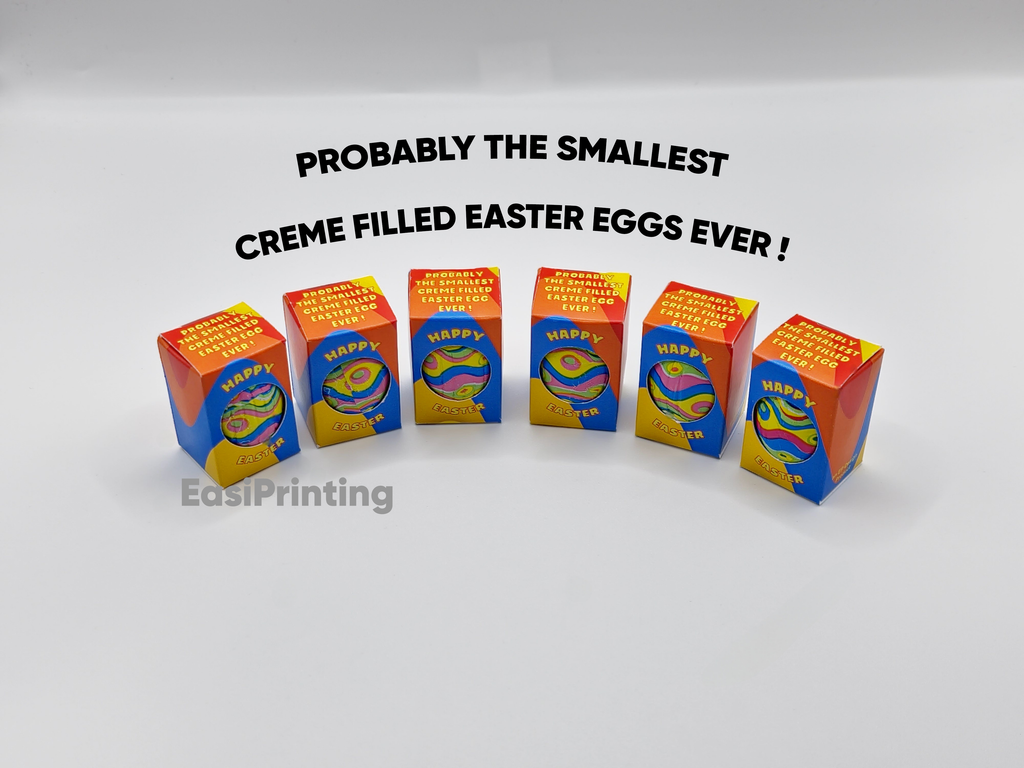 Small boxes labeled 'Happy Easter' with colorful packaging on a white background, featuring text about creme-filled Easter eggs.